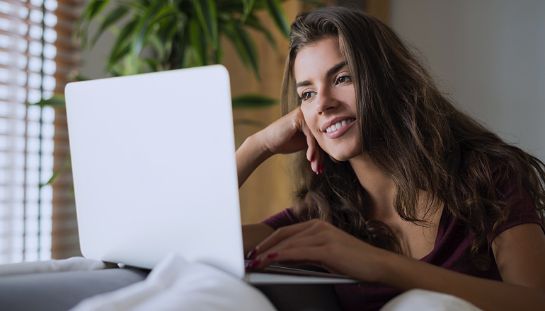Mujer con el ordenador, agilizando el proceso para obtener un atestado policial online